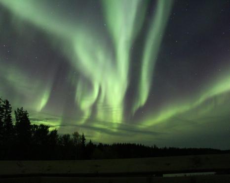 Green aurora borealis on the night sky.