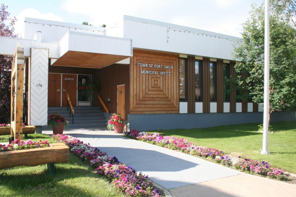 Exterior of Town of Fort Smith Municipal Office. The building has a modern, square façade with with wooden walls.