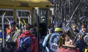 Excited skiers prepare to board the bus that will take them to the starting point.