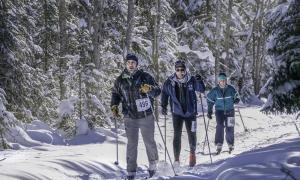 A trio skis through the groomed trails of the Thebacha Loppet